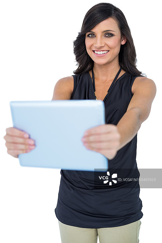 微笑优雅的黑发模特拿着她的平板电脑图片素材