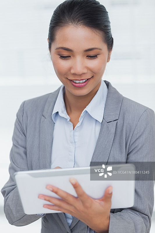 快乐的女商人在她的平板电脑上摆姿势滚动图片素材