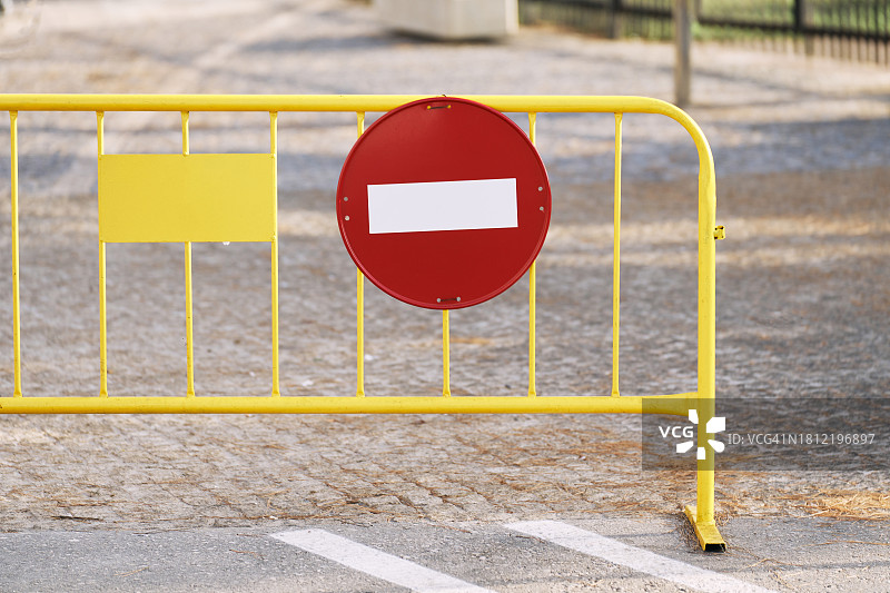 街道上的限制金属栅栏上有一个红色的标志，上面写着标志，正面视图图片素材