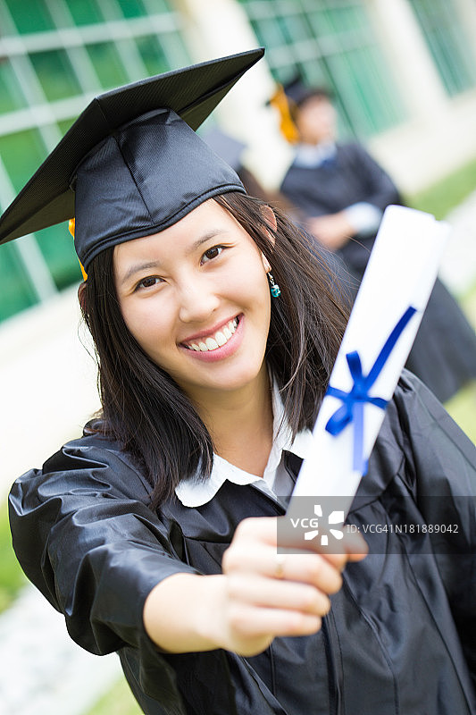 快乐的亚洲女毕业生拿着文凭图片素材