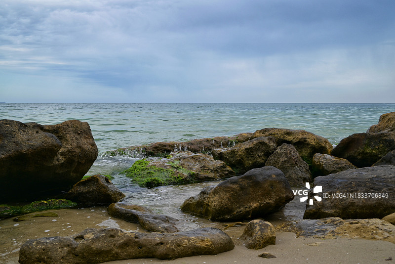 海滩上的岩石对着天空的风景图片素材