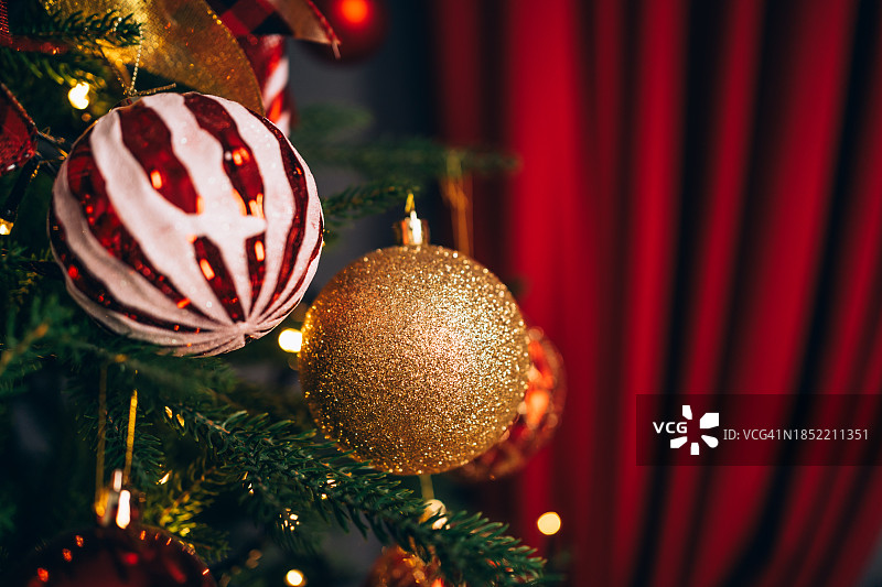 家里的圣诞树上挂满了红色、金色和白色的玩具。圣诞节和新年庆祝概念。作为贺卡的完美图片。图片素材