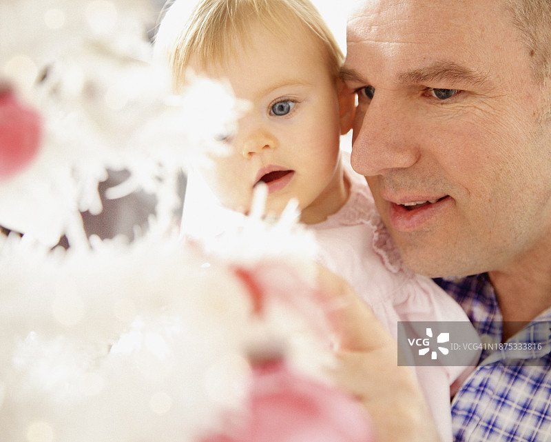 爸爸和小女儿看着圣诞树图片素材