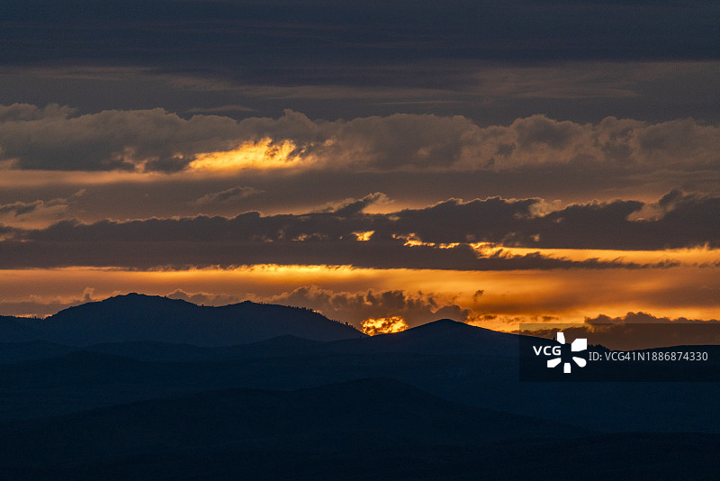 美丽的落日映衬着群山的剪影图片素材