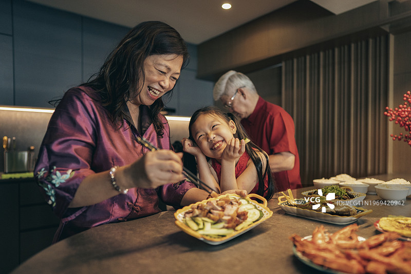 爷爷奶奶和孙女在厨房里为中国新年准备食物图片素材