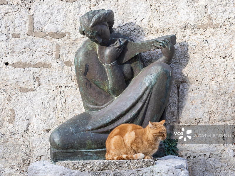 猫坐在一个音乐家的青铜雕塑，奥索尔，克雷斯岛，克瓦纳湾湾湾，克罗地亚，欧洲图片素材