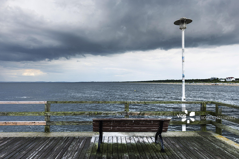波罗的海岸边破旧码头上的长椅，海，波罗的海，假日，阴郁，压抑，无人，空虚，暴风雨，坏天气，多云，乌云，雨云，景色，心情，气氛，德国，欧洲图片素材