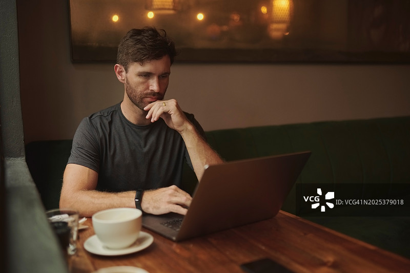 男人，阅读和远程工作的笔记本电脑在咖啡店和作家与自由项目的想法。人，策划和新闻研究的咖啡馆在线文章，博客或滚动在电脑上图片素材