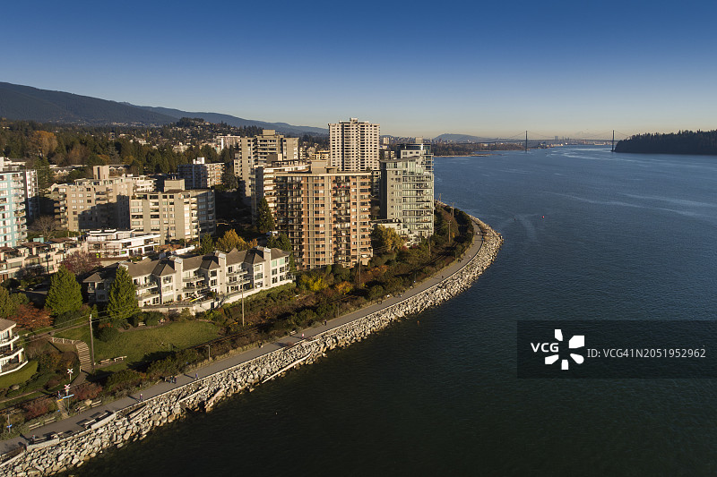 加拿大不列颠哥伦比亚省西温哥华的海滨社区，位于伯拉德湾和太平洋的乔治亚直道上，高耸的沿海山脉和柏树在它后面，越过狮子门大桥到温哥华图片素材