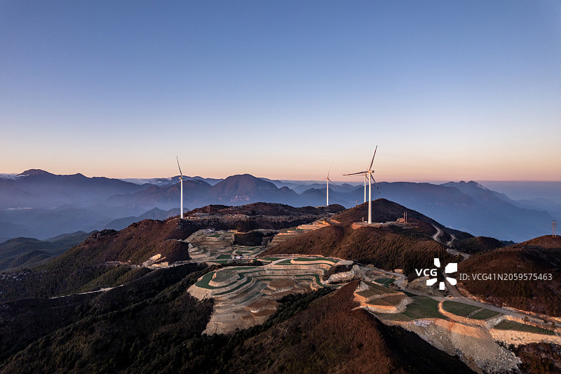 黄昏时分，山上的梯田和风力涡轮机图片素材