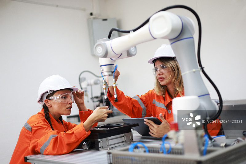 女维修工程师用机械臂和分析人员在实验室里用图表数据检测的静态信息工作图片素材