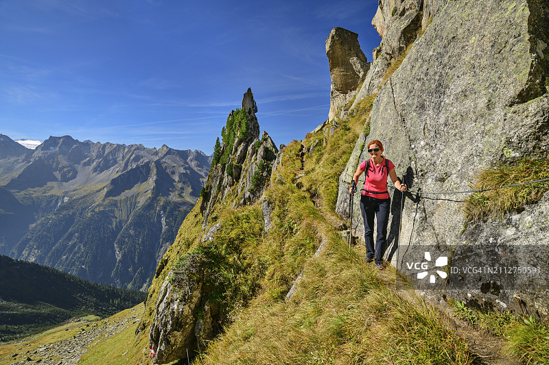 奥地利，蒂罗尔，女徒步旅行者跟随阿沙芬堡霍恩韦格步道在齐勒勒阿尔卑斯山脉图片素材