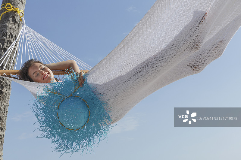 热带海滩上吊床上的女人图片素材