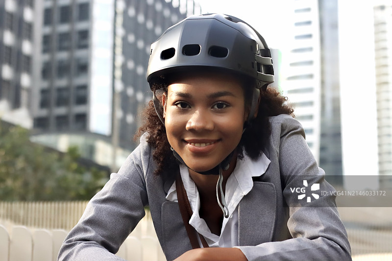 在城市中移动的女人，戴上她的自行车头盔图片素材