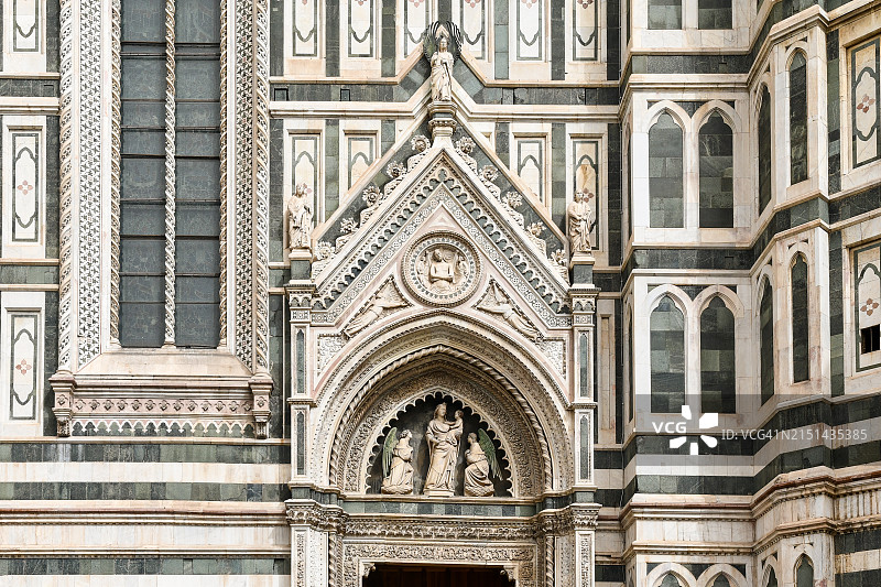 意大利托斯卡纳佛罗伦萨，佛罗伦萨大教堂南侧的细节，教堂门上方有一个新月形图案，上面有圣母和圣婴的雕像(1346年)，站在天使中间图片素材
