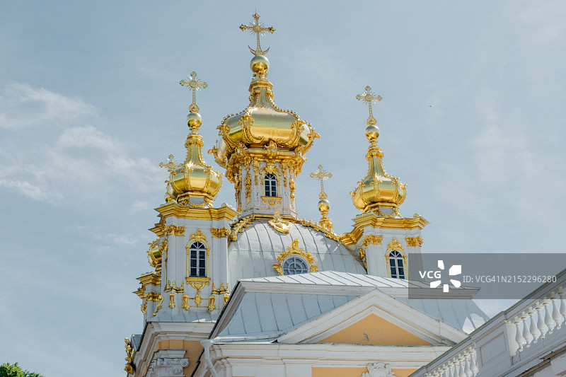Peterhof的宫殿。教堂。金色圆顶的翅膀下的盾徽。装饰的细节。天空中的鸟群博物馆:俄罗斯，彼得霍夫，2023年7月13日图片素材