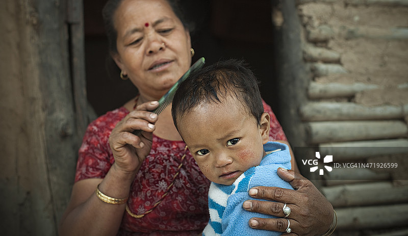 尼泊尔人:孙子在用祖母的梳子梳头图片素材