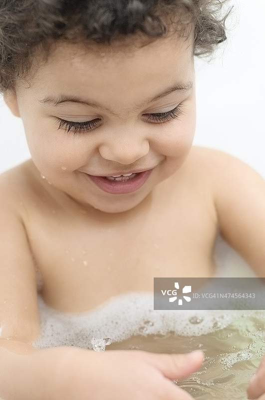 人物:蹒跚学步的孩子(2-3)在浴室里玩耍的肖像。图片素材