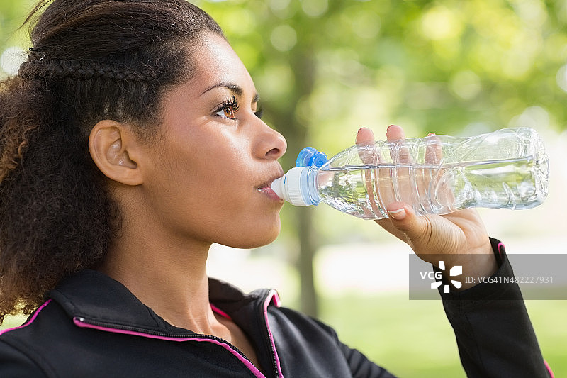 在公园里喝水的疲惫的女人的近侧视图图片素材