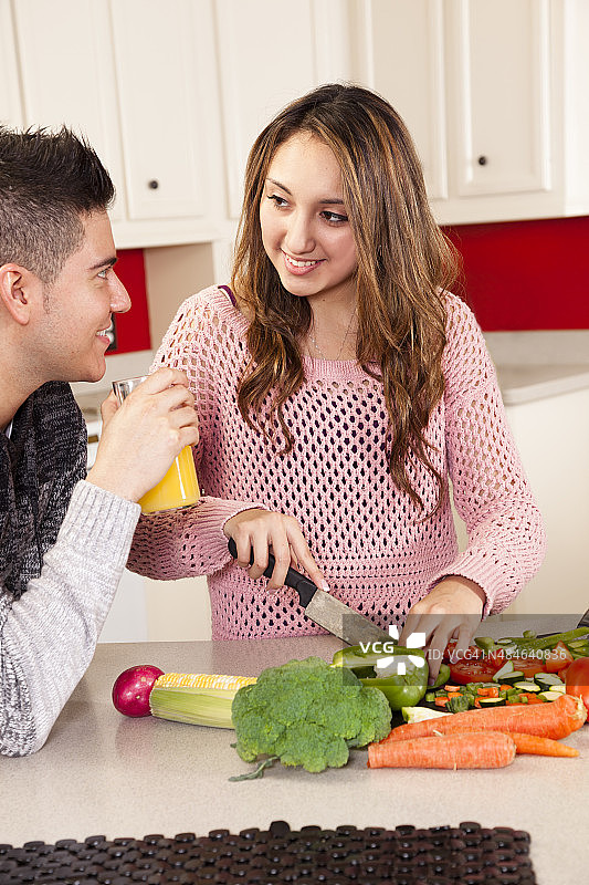 年轻夫妇准备健康的午餐。厨房。水果、蔬菜、沙拉。图片素材
