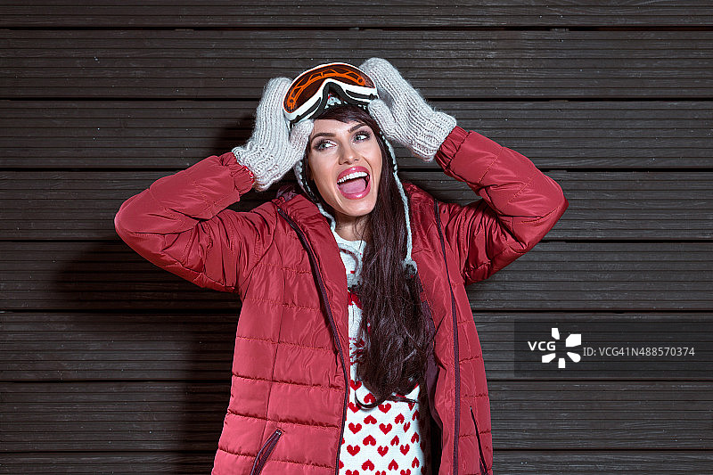 快乐的女人在冬天的装备，穿着羽绒服和护目镜图片素材