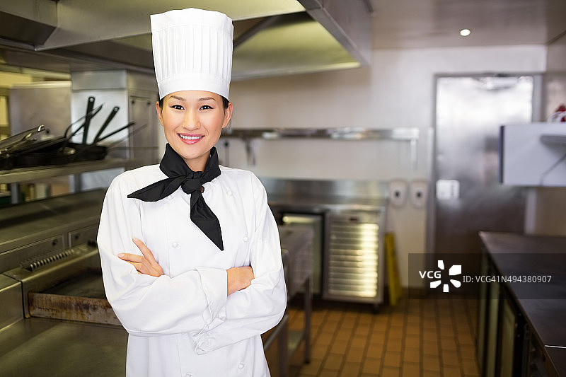 微笑的女厨师在厨房的肖像图片素材