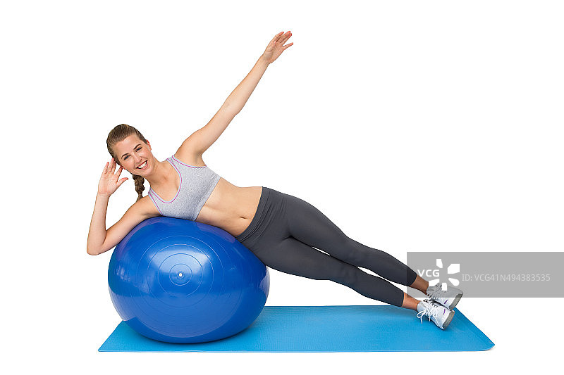 一个健康的女人在健身球上伸展的肖像图片素材