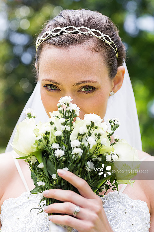 年轻的新娘从花园里的花束中窥视图片素材