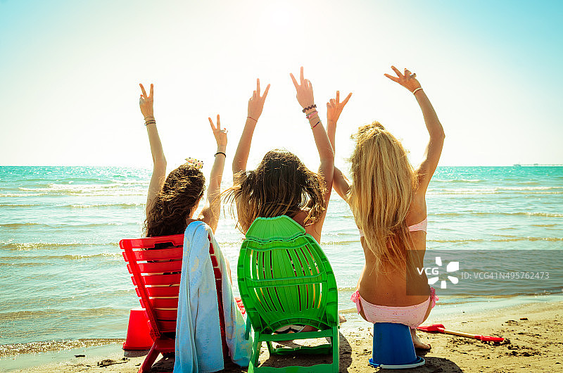 三个快乐的朋友在海滩上度过夏天图片素材