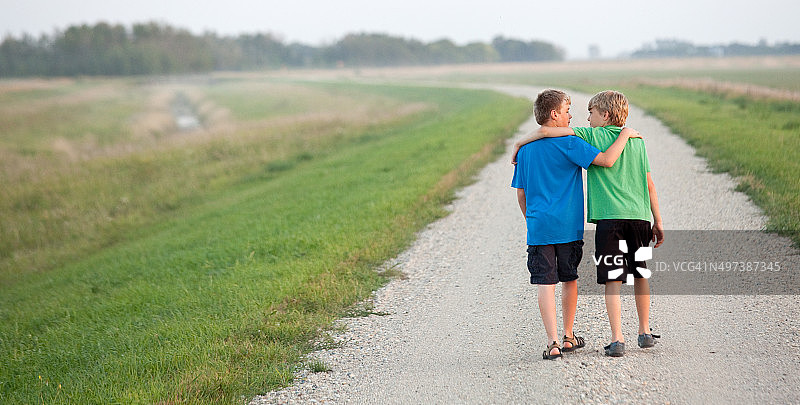 两个男孩走在乡间小路上图片素材