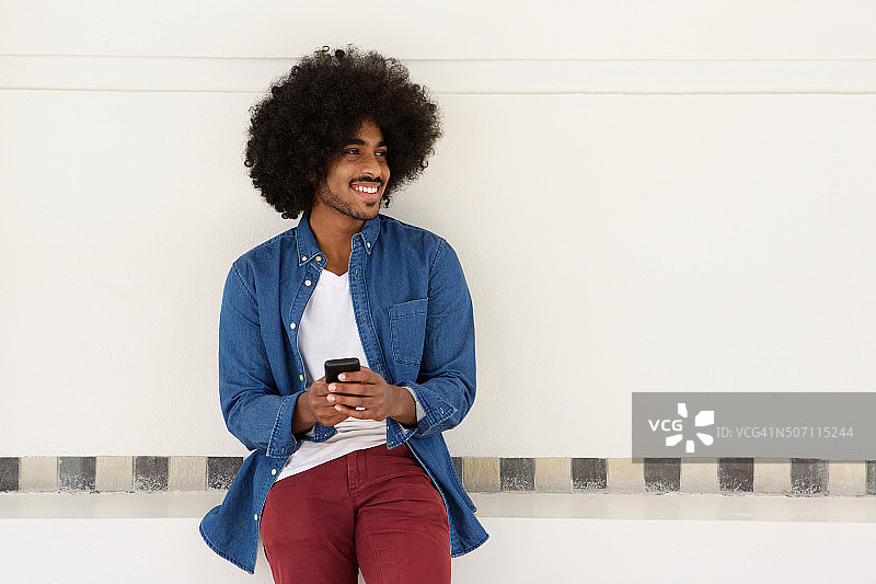 微笑的年轻黑人男子使用手机图片素材