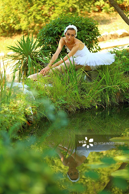 在湖镜旁的公园里有个芭蕾舞演员图片素材