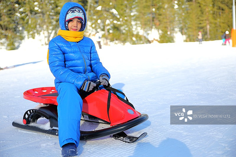 小男孩和他的雪橇在冬天图片素材
