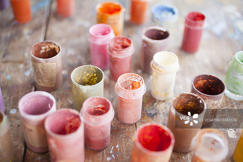 桌子上的罐子里装着不同颜色的油画图片素材