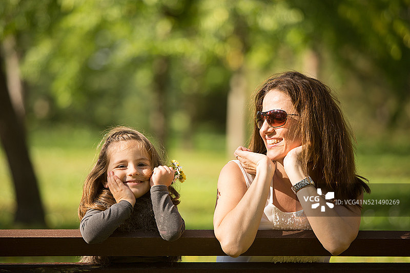 母亲和女儿坐在长凳上图片素材