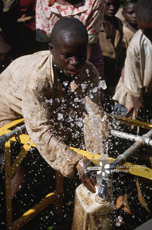 卢旺达难民在乐施会水龙头，坦桑尼亚图片素材