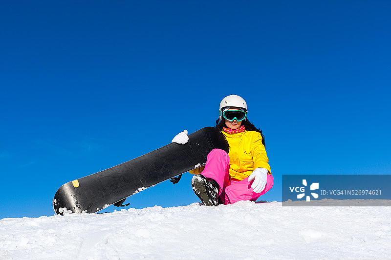 滑雪女子坐在雪坡上图片素材