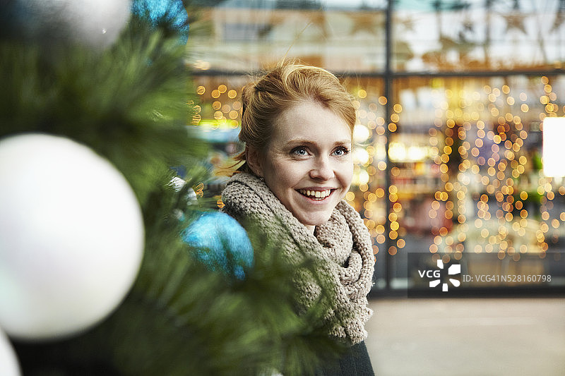 年轻女子站在商场里，临近圣诞节图片素材