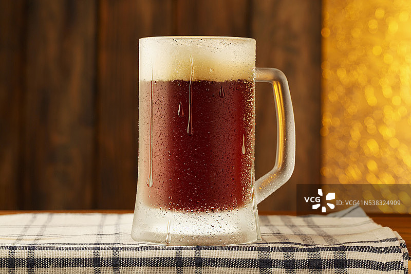 酒吧木质柜台上的一杯冰凉的啤酒图片素材