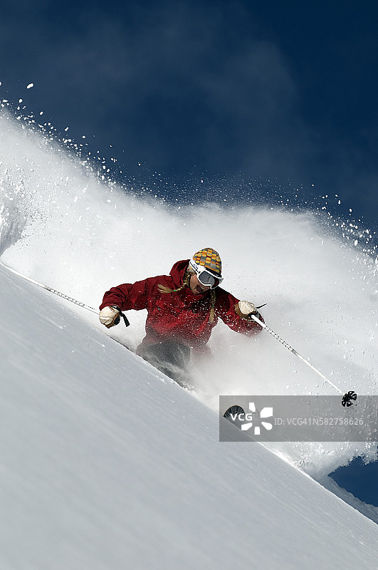 女人在粉状雪中滑雪图片素材