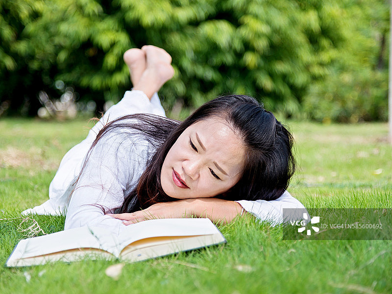 一个在公园里看书的亚洲女人图片素材