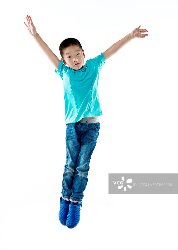 年轻的亚洲男孩在白色背景下跳跃图片素材