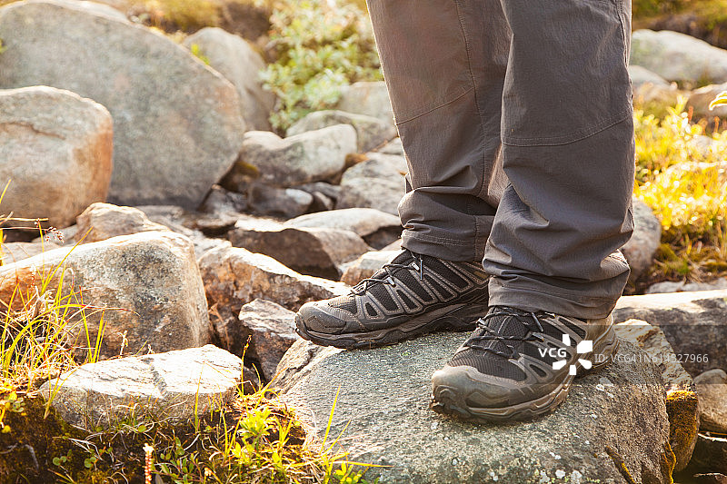 徒步旅行者站在岩石上，脚穿靴子图片素材