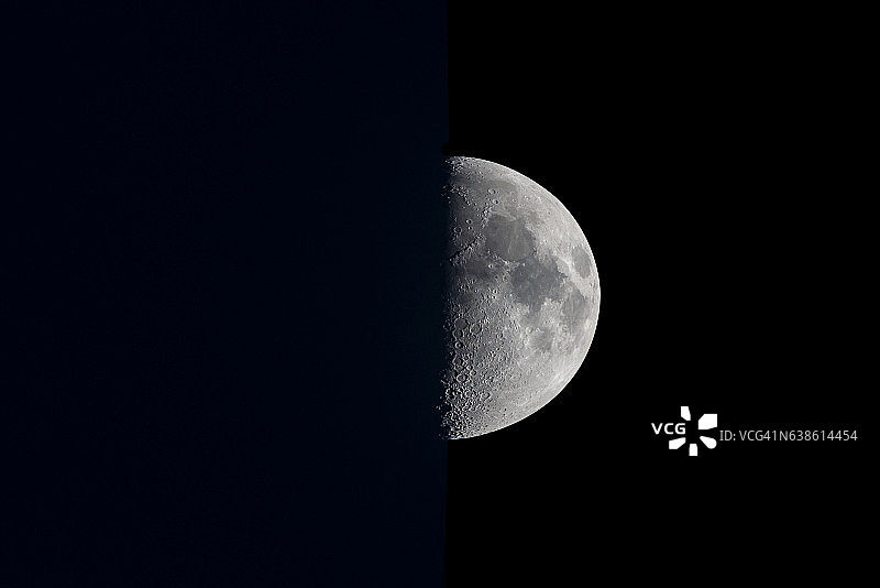 黑暗天空中的半月形月亮。图片素材