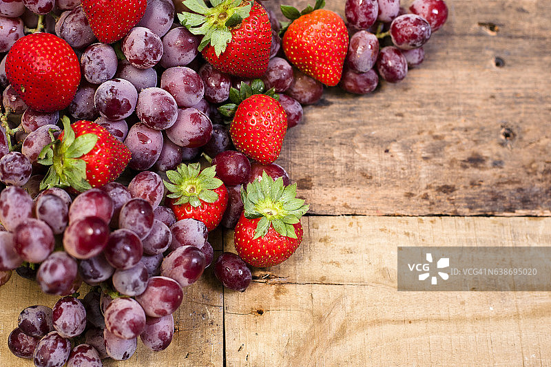 新鲜，有机草莓，葡萄水果放在木桌上。图片素材
