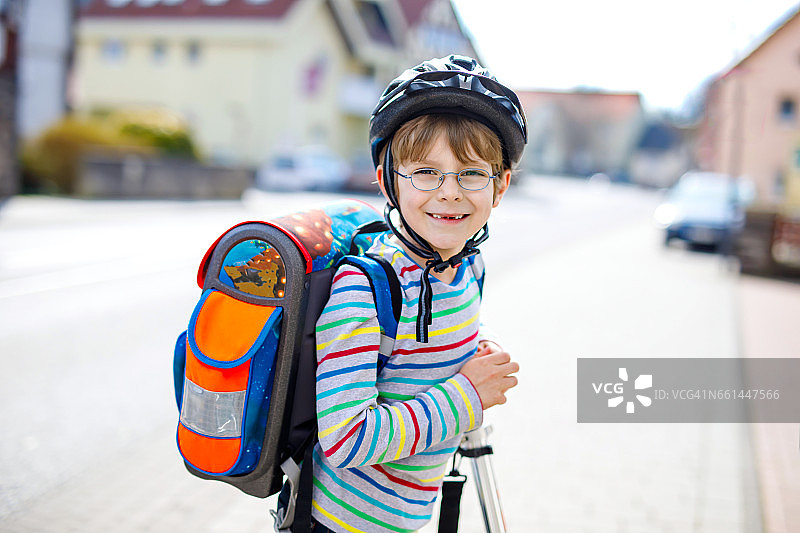 一个戴着头盔的小男孩骑着他的摩托车在城市里图片素材