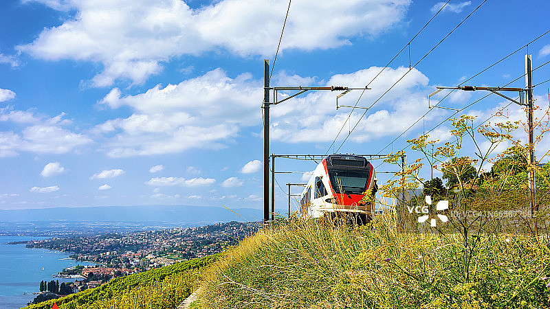 火车在拉沃葡萄园梯田附近的日内瓦湖瑞士山脉图片素材