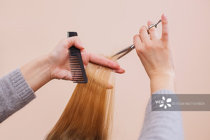 理发师用剪刀为一个年轻的女孩理发图片素材