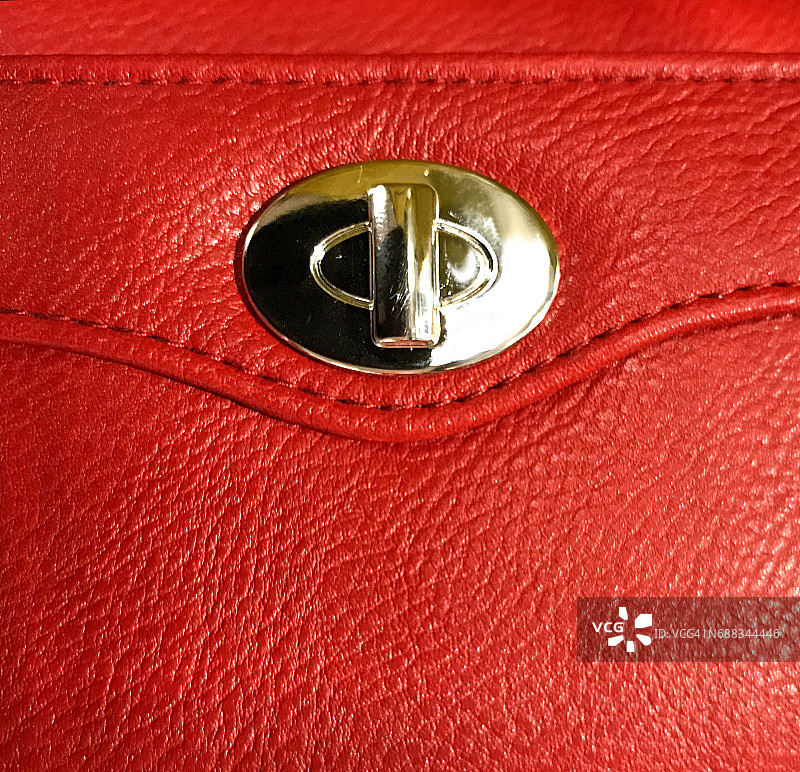 一个红色女士钱包上的金属锁的特写图片素材