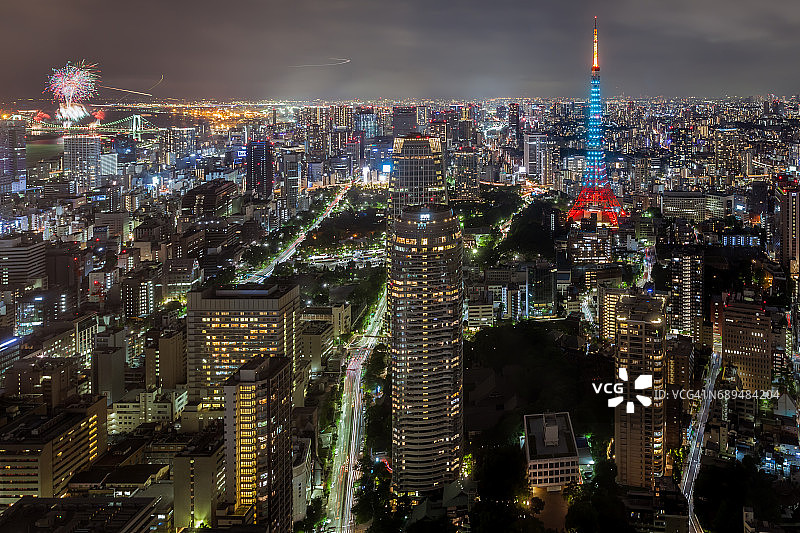 东京城市天际线在黄昏与东京塔和摩天大楼照亮港区，东京，日本。台场彩虹桥烟花活动同时举行。图片素材